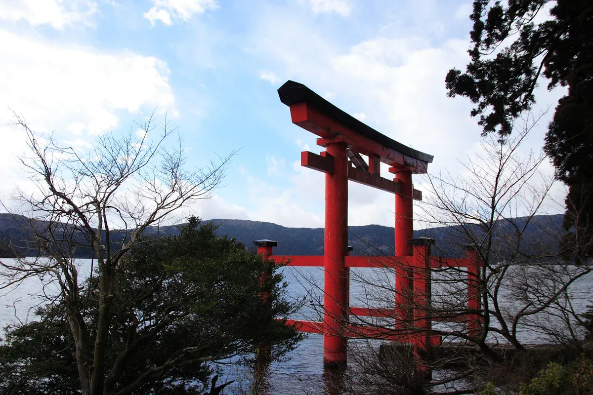 Red torii gate standing in Lake Ashi near Hakone Shrine on a Hakone day trip from Tokyo